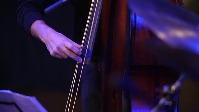 Double bass. Hands playing contrabass player musical instrument.