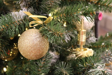 Christmas texture of green artificial fir branches of different sharpness with gold toys and mechanisms.