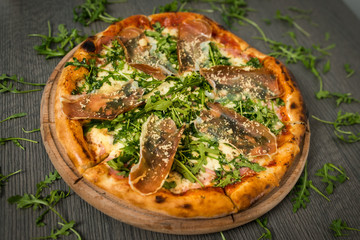 Delicious tasty pizza with ingredients on wooden table