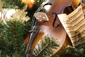 Elements of a toy viola of different sharpness among artificial green needles with Christmas tree...