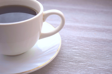 white mug of coffee with a saucer on the table
