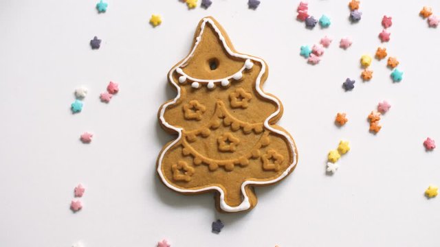Yummy sweet gingerbread cookies with color cream and springles on home kitchen surface. Close up of Christmas holiday food. 4k.