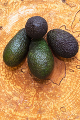 Avocado four pieces on a wooden background. Vertical photo