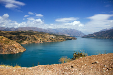 Fototapeta premium Picturesque landscape and lake, Charvak reservoir, mountains on sunny day background