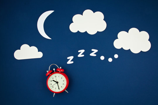 Snoring classic alarm clock on blue pastel trendy background. Flat lay, top view mock up