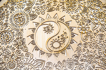 Relief drawing on a tree of light yellow color in the form of circles of flowers of petals. Backgrounds, design, structures, textures.