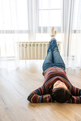 Woman laying on floor with feet raised up on radiator for warming up