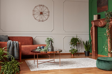 Stylish copper colored coffee table in front of comfortable corner sofa in trendy living room