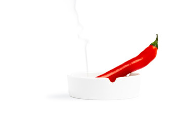 red chilly pepper smoking on a ashtray