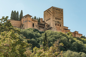 Fototapeta na wymiar View of the famous palace of Alhambra in Granada, Spain. Low angle view of the majestic palace and fortress