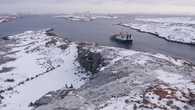 Fishing vessel in winter, Tr&aelig;na archipelago, Nordland, Northern Norway, aerial drone shot