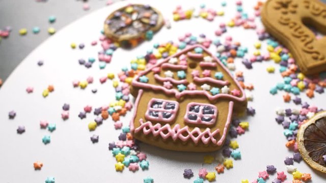 Yummy sweet gingerbread cookies with color cream and springles on home kitchen surface. Close up of Christmas holiday food. 4k.