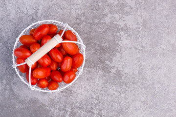 Fresh red cerry tomatoes on a grey structured background