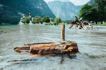 A piece of wood in the Königssee in front of the St. Bartholomew's church in Bavaria, Germany