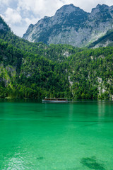 A tourist ship is cruising over the green lake Koenigssee (K&ouml;nigssee) in Bavaria, Germany
