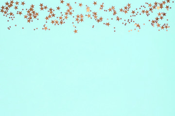 Frame from golden stars glitter confetti on blue background. Festive backdrop.