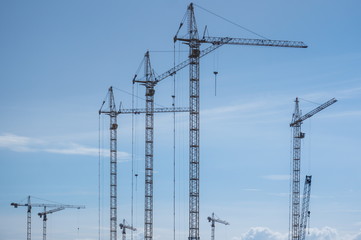 Group of building cranes against the sky