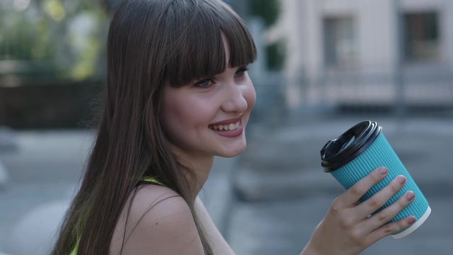 Portrait of happy girl with dimples on face holds a cup of tea and smiles