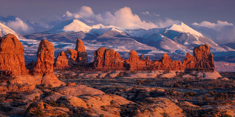 FEBRUARY 15, 2019 -  ARCHES NATIONAL PARK, UTAH , USA - Arches National Park, Utah at sunset - Lasalle Mountains in distance - obrazy, fototapety, plakaty