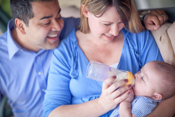 Obraz na płótnie Canvas Happy Attractive Mixed Race Couple Bottle Feeding Their Son.