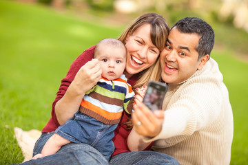 Happy Mixed Race Parents and Baby Boy Taking Self Portraits at the Park