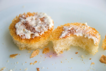 two round croutons with white sauce on top on a white background close up