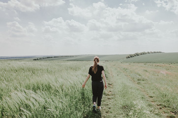 Fototapeta premium a woman walking in green field