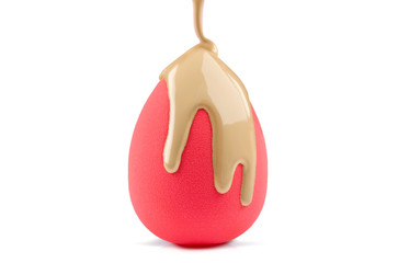 Makeup liquid foundation pouring on make-up blender sponge, closeup. Foundation beauty facial...