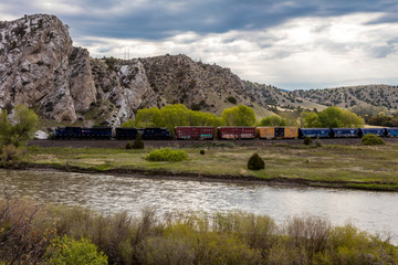 MAY 23 2019, USA - THREE FORKS, MT - Missouri River Breaks National Monument, the source of the Missouri River, freight train runs along river