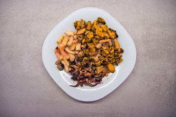 white plate on a gray kitchen table with seafood top view