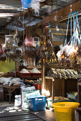 Dried fish tied into several bundles for sale, hanging from above, in a local fish market in Semporna, Sabah.