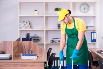 Young male contractor cleaning the office