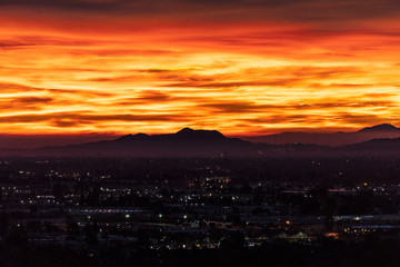 Fiery predawn view across the San Fernando Valley towards Griffith Park in the city of Los Angeles, California.  