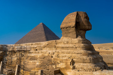 Sphinx with view  of the Great Pyramids of Giza, Cairo, Egypt