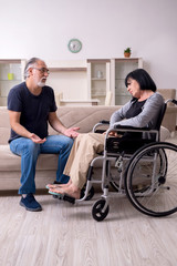 Old husband looking after disabled wife