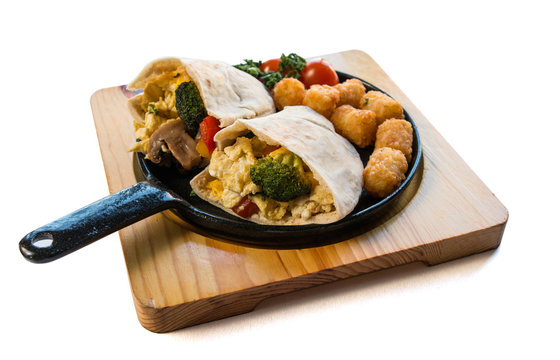 Close Up Image Of Breakfast Burrito With Broccoli, Scrambled Egg, Hash Browns On A Black Pan