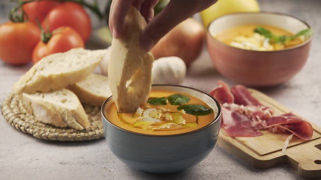 Eating salmorejo with bread and serrano ham