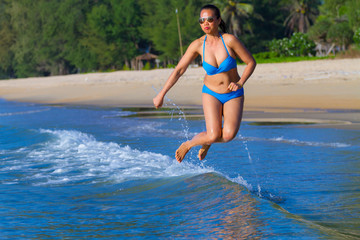 Woman shpae sexy and bikini blue jump at beach