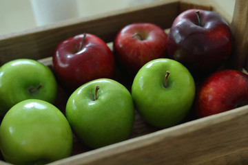 red and green apple fruit in harvest wood basket