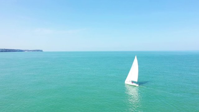 Un voilier solitaire au bord de la c&ocirc;te normande dans la Manche lors d'une journ&eacute;e ensoleill&eacute;e