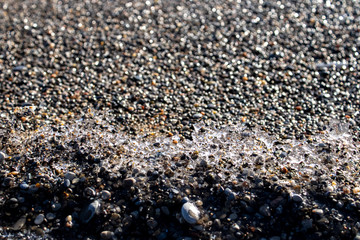 Ice shapes on the beach from rocks and pebbles in the winter
