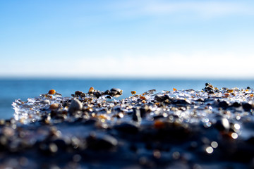 Ice shapes on the beach from rocks and pebbles in the winter