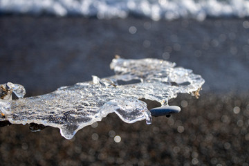 Ice shapes on the beach from rocks and pebbles in the winter