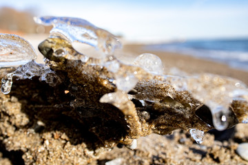 Ice shapes on the beach from rocks and pebbles in the winter