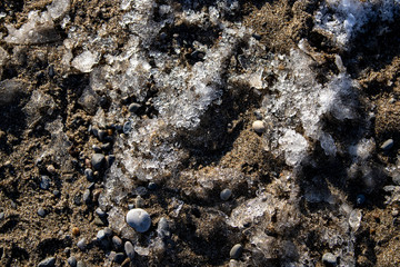 Ice shapes on the beach from rocks and pebbles in the winter