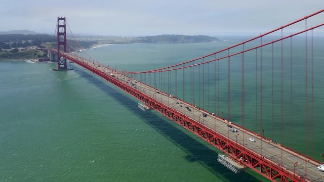 Aerial 4K footage of the picturesque and well-recognizale view of Golden Gate Bridge.Camera moves down from the height to the water surface overlooking the beautiful low-angle bridge view.