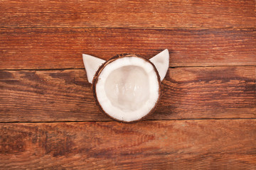 Coconut pieces on old wooden background. Top view. Cat face shape.