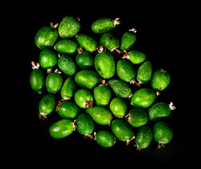 Fresh feijoa fruits (acca sellowiana, pineapple guava) isolated on a black background.
