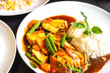 Thai-style Stir-fried Mixed Vegetables Tofu with jasmine white rice. Traditional Thai dish food on table.