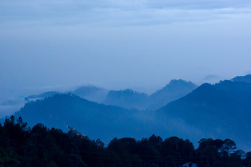 dusk shot of hills covered with fog and clouds shot at McLeodganj dharamshala India